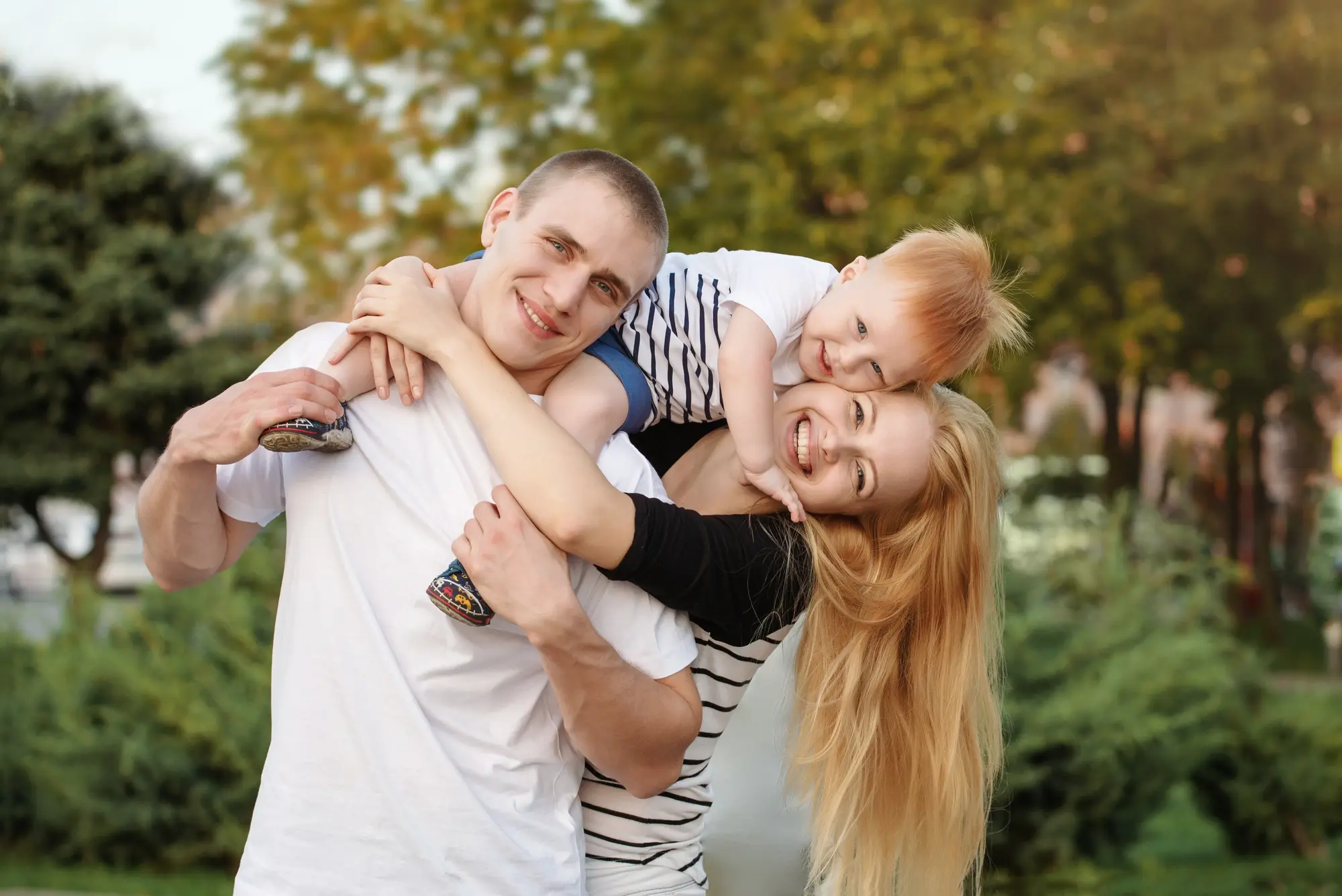 A father hugging his two children outdoors
